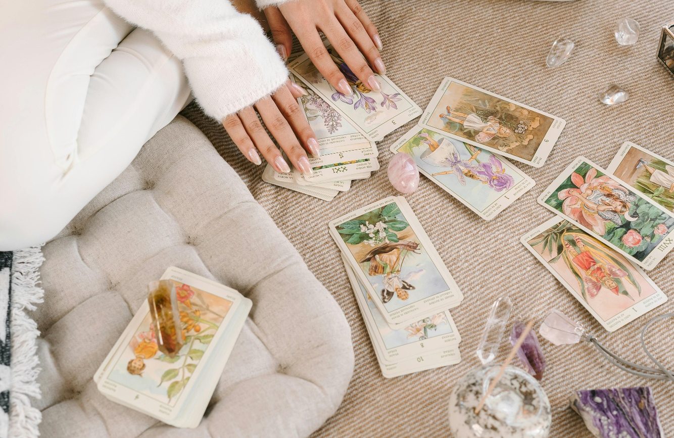 Tirage de tarot personnalisé Un ensemble de cartes de tarots et oracles illustrées avec divers symboles mystiques et spirituels